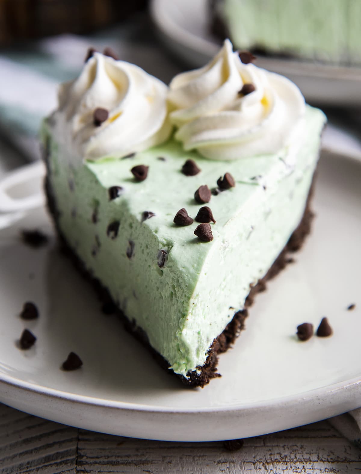 A piece of no bake mint chocolate cheesecake on a white plate.