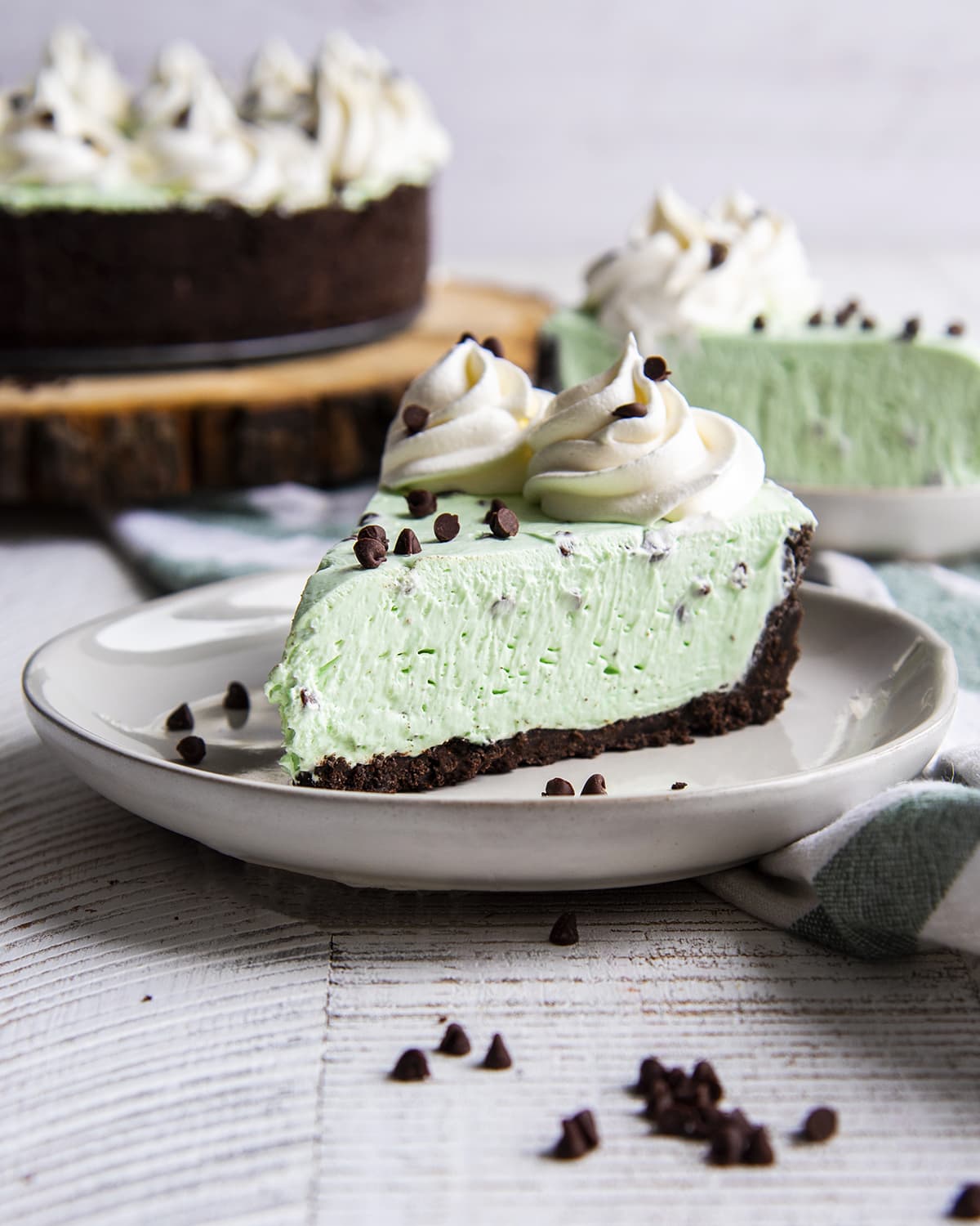 A slice of mint green no bake cheesecake on a white plate.