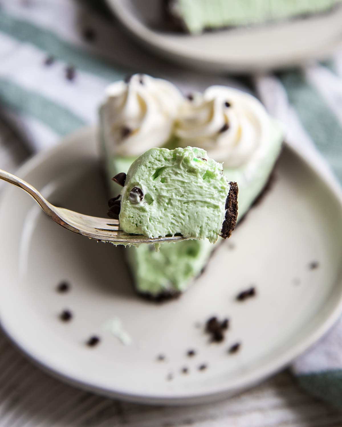 A bite of mint cheesecake on a fork.