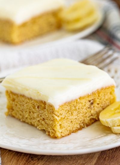 A banana blondie with cream cheese frosting on a plate.