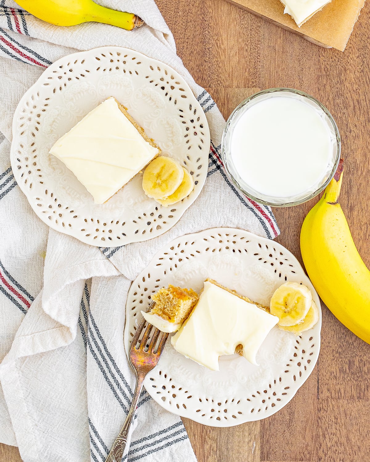 An overhead photo of two banana blondies on white plates.