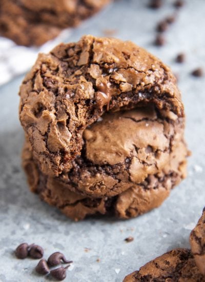 Brownie cookies in a stack. The top cookie has a bite out of it.