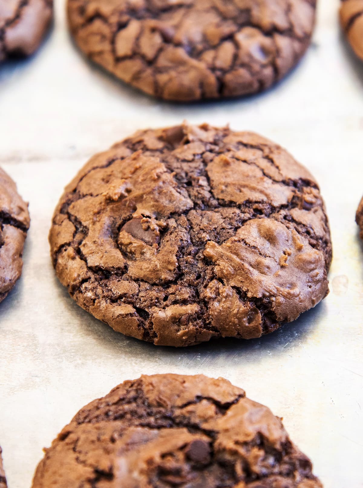 A close up of a chocolate brownie cookie with a crinkly top.