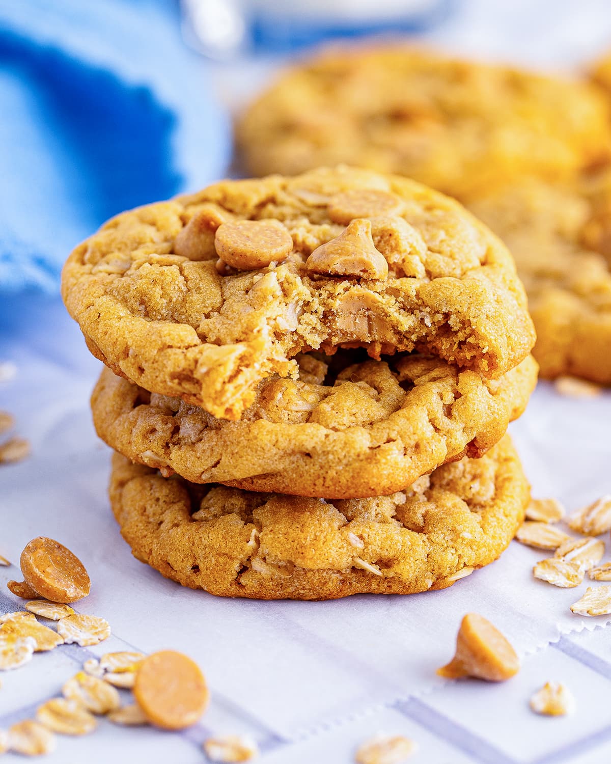 Three peanut butter oatmeal cookies in a stack with a bite out of the top.