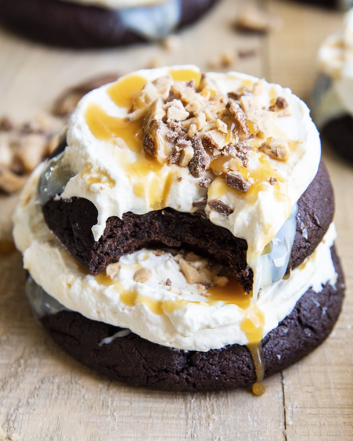 A close up of a better than sex cookie topped with whipped cream, caramel, and toffee pieces.