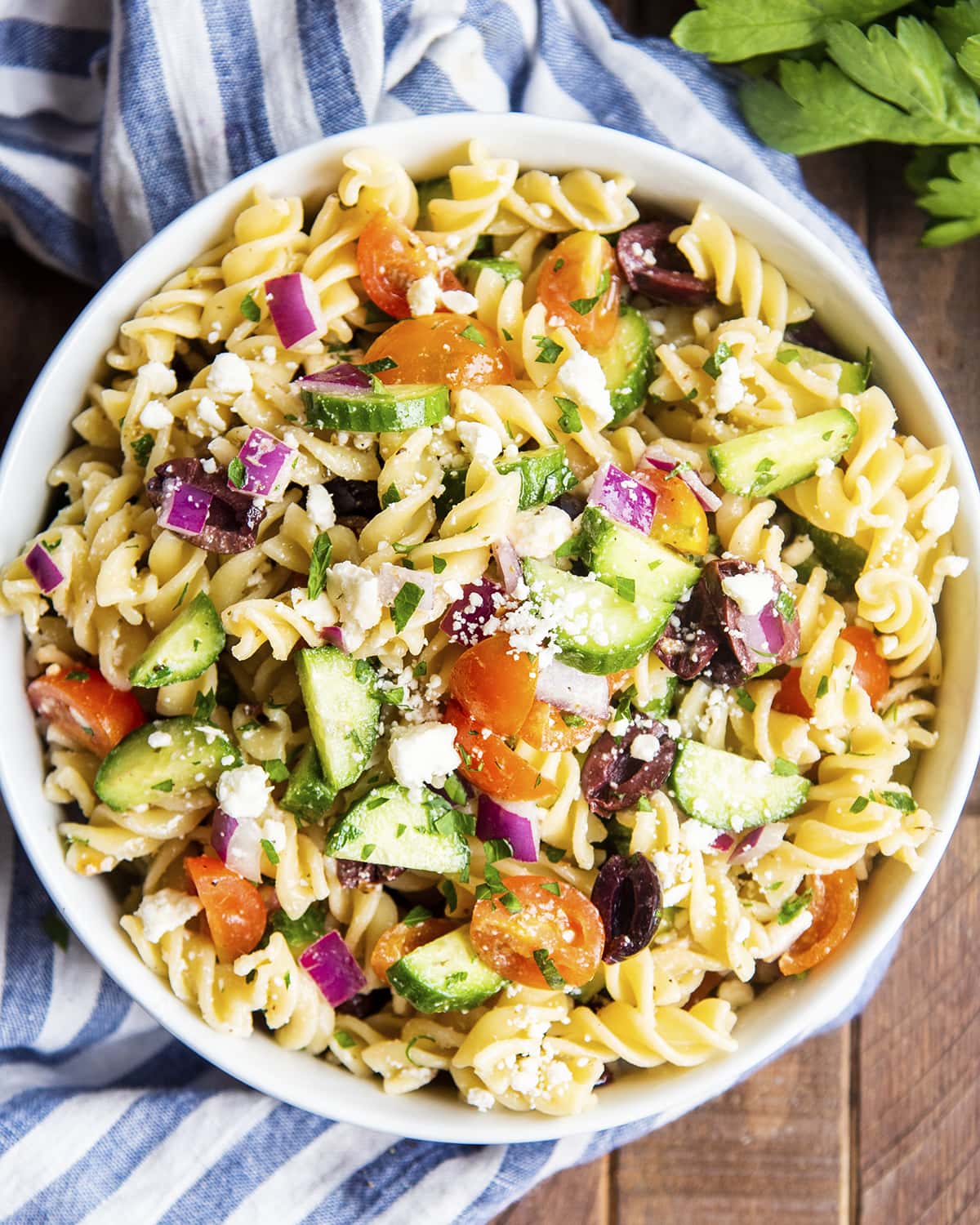 An overhead photo of a bowl of greek pasta salad.