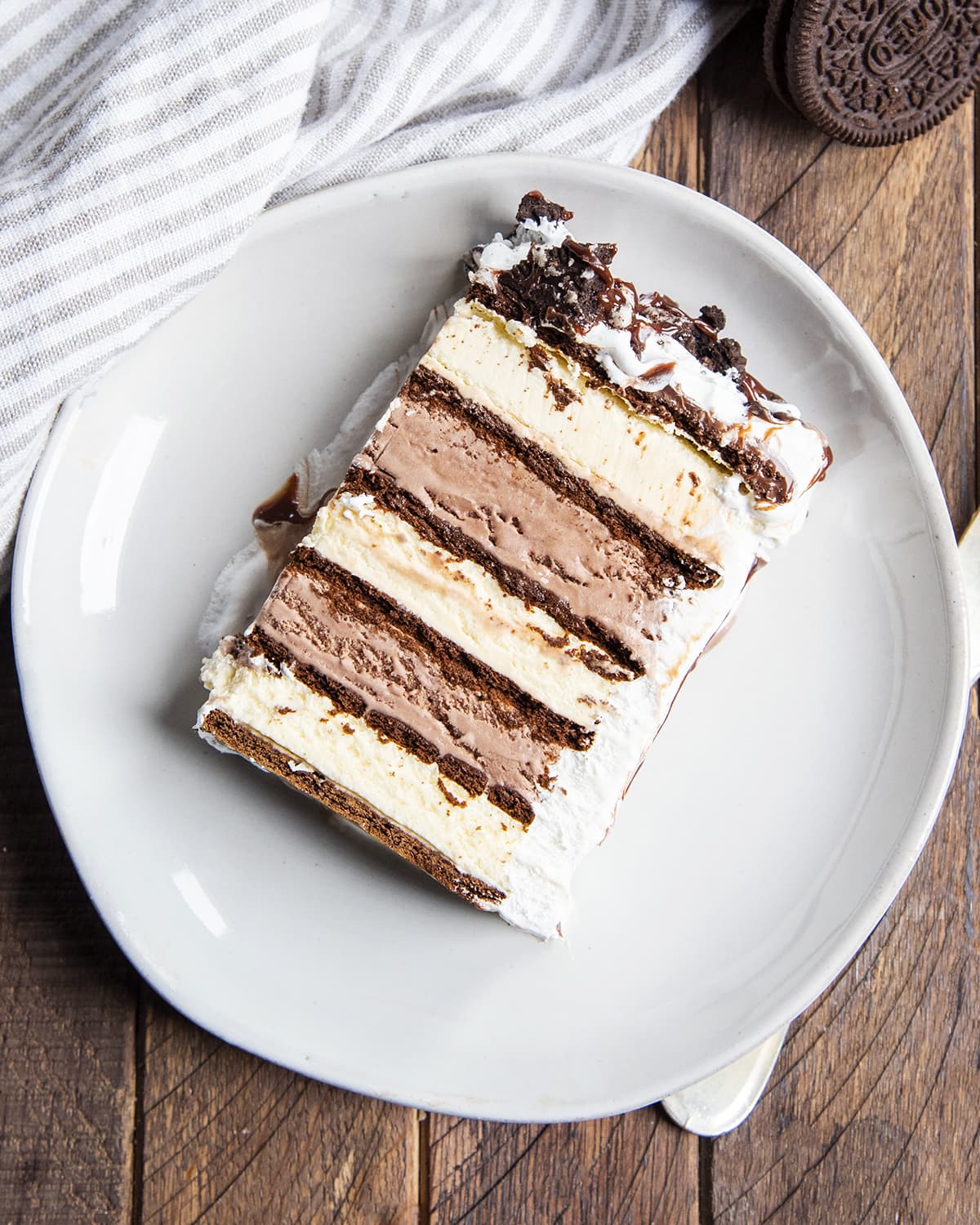 An overhead photo of layered ice cream sandwich cake on a plate.