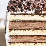 A close up of the inside of an ice cream sandwich cake layered with ice cream sandwiches, and chocolate ice cream.