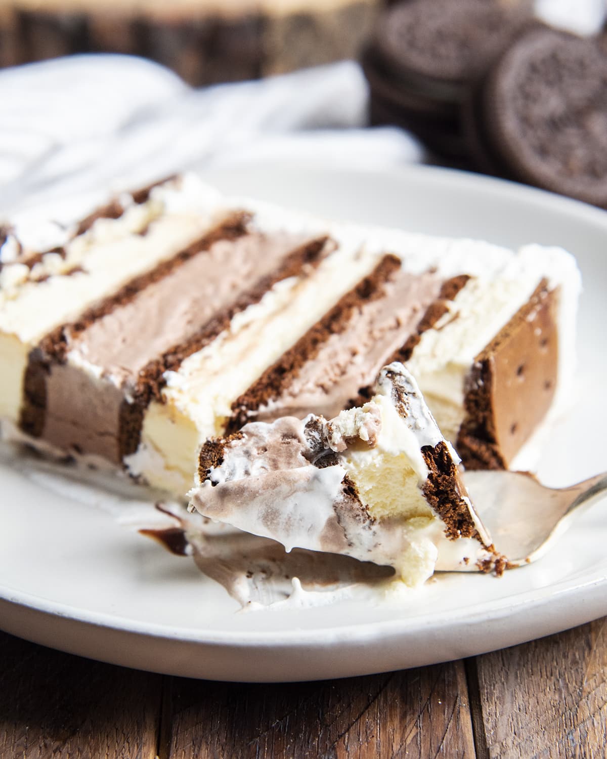A forkful of ice cream sandwich cake in front of a slice of it.
