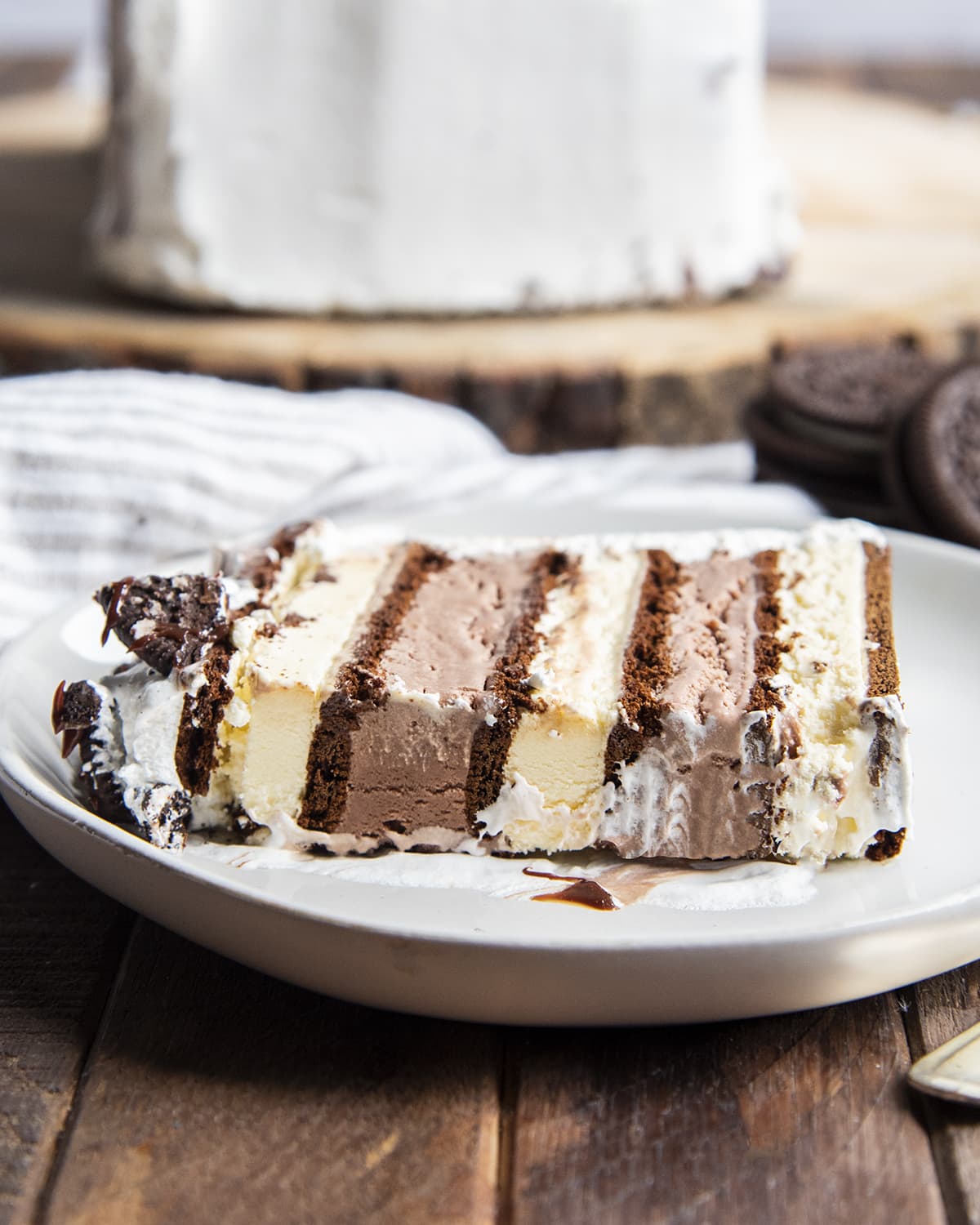 A piece of an ice cream sandwich cake with vanilla ice cream sandwiches, and chocolate ice cream.