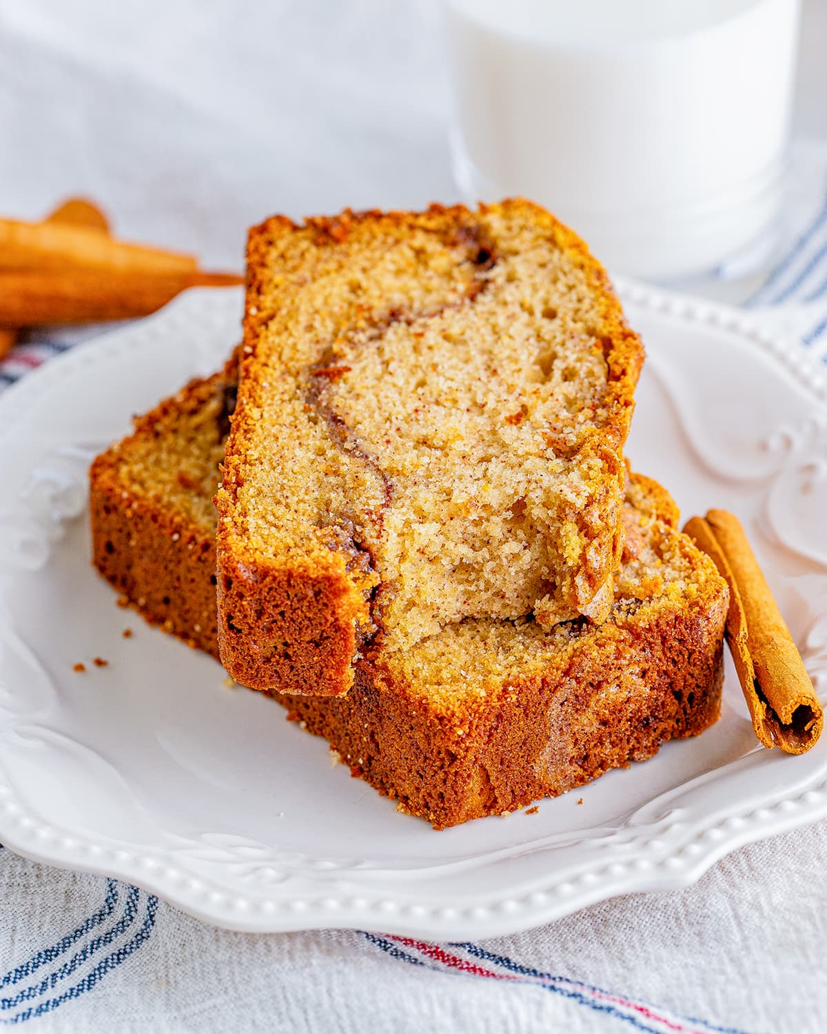 A stack of two pieces of cinnamon quick bread with a cinnamon swirl in the middle.