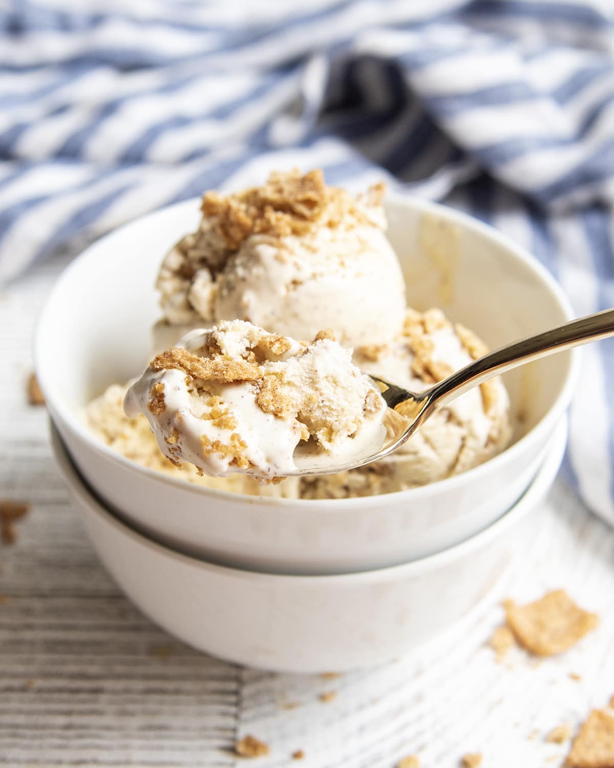 A spoonful of ice cream topped with Cinnamon Toast Crunch Cereal pieces. 