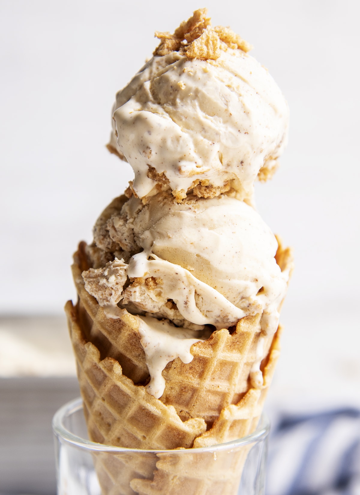 An waffle ice cream cone full of two scoops of Cinnamon Toast Crunch Ice Cream.