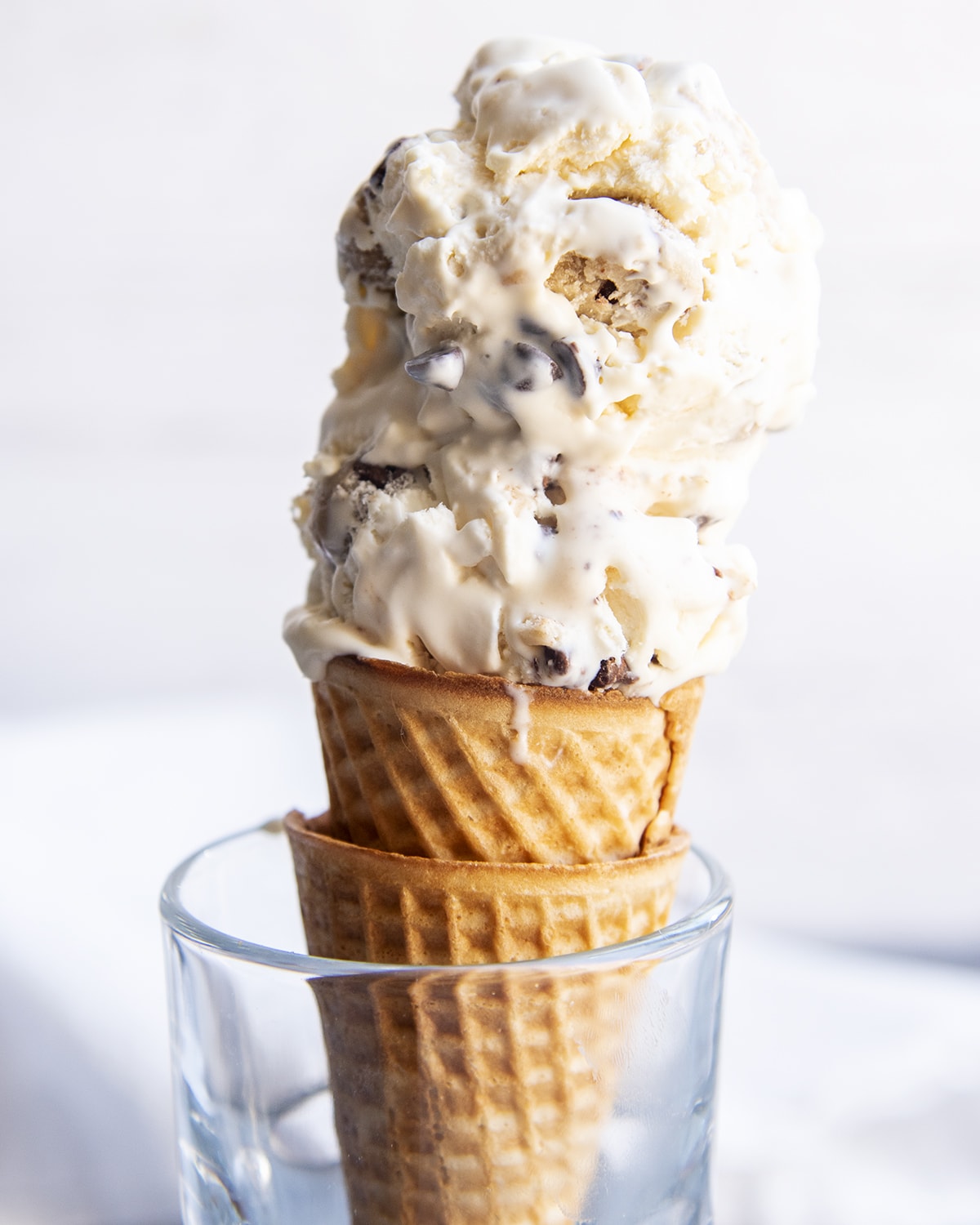 Two scoops of chocolate chip cookie dough ice cream on a cone.