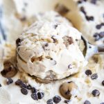A close up of a scoop of cookie dough ice cream with chocolate chips in it.
