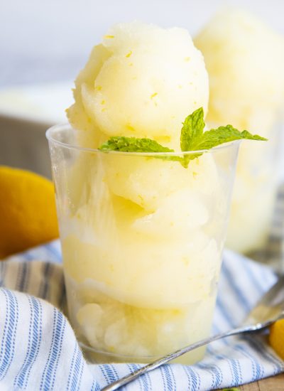 A close up of a cup of scoops of fresh lemon sorbet.