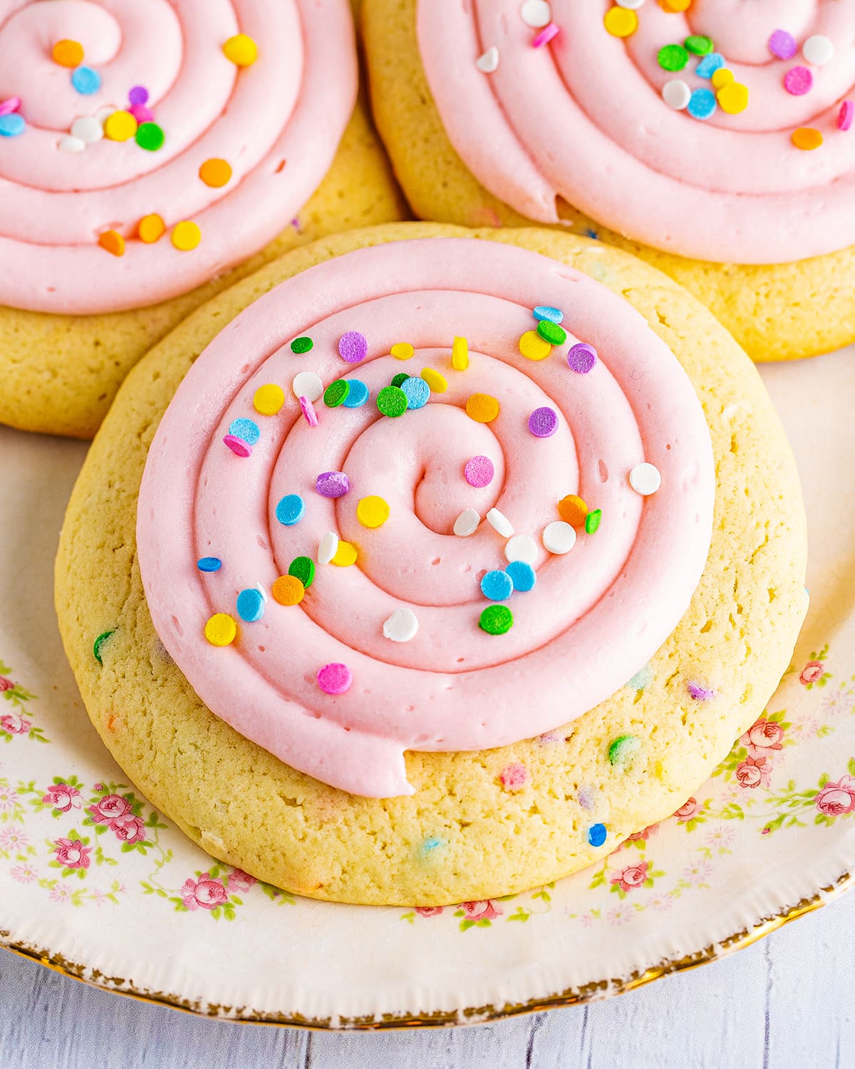 An overhead photo of a pink frosted sprinkle cookie.