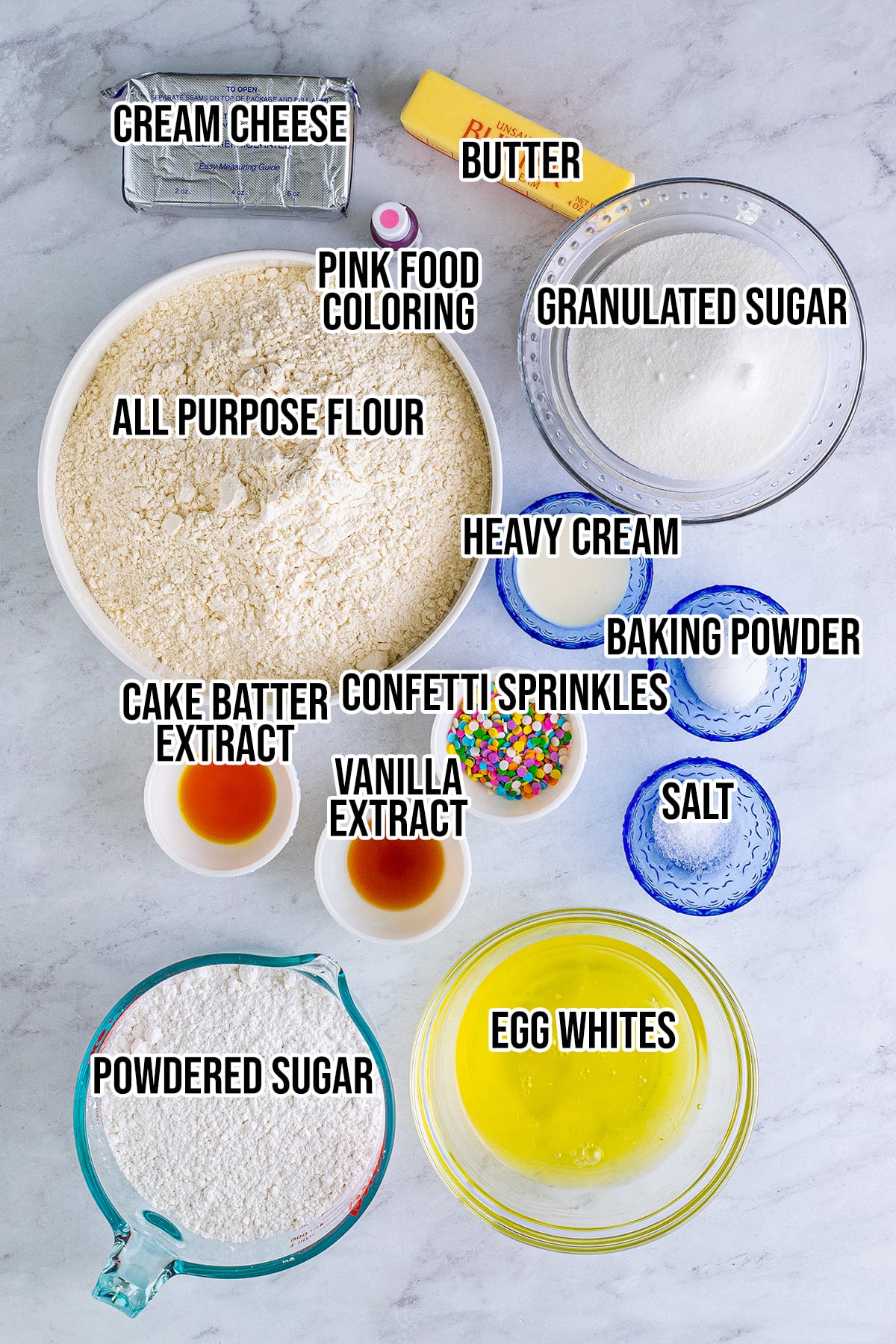 An overhead photo of the ingredients needed to make confetti cake cookies, with a label over each ingredient.