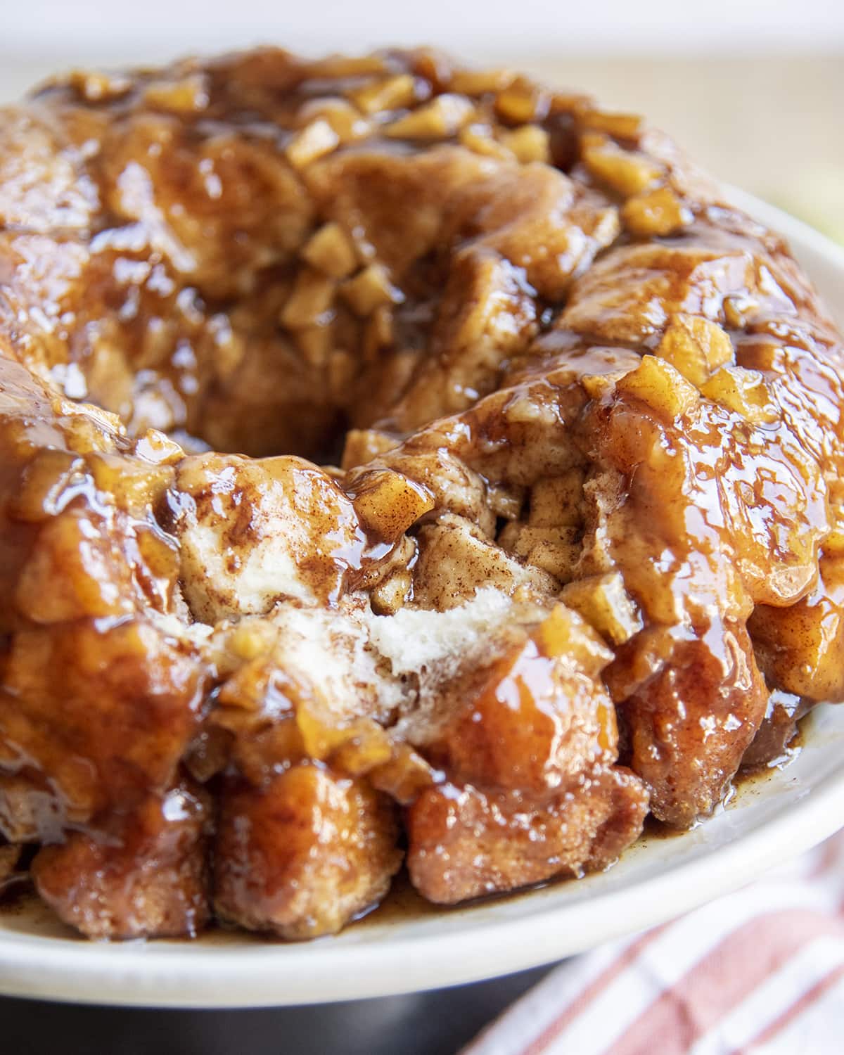 Monkey bread on a white plate with a few pieces taken out to show the middle of the bread.