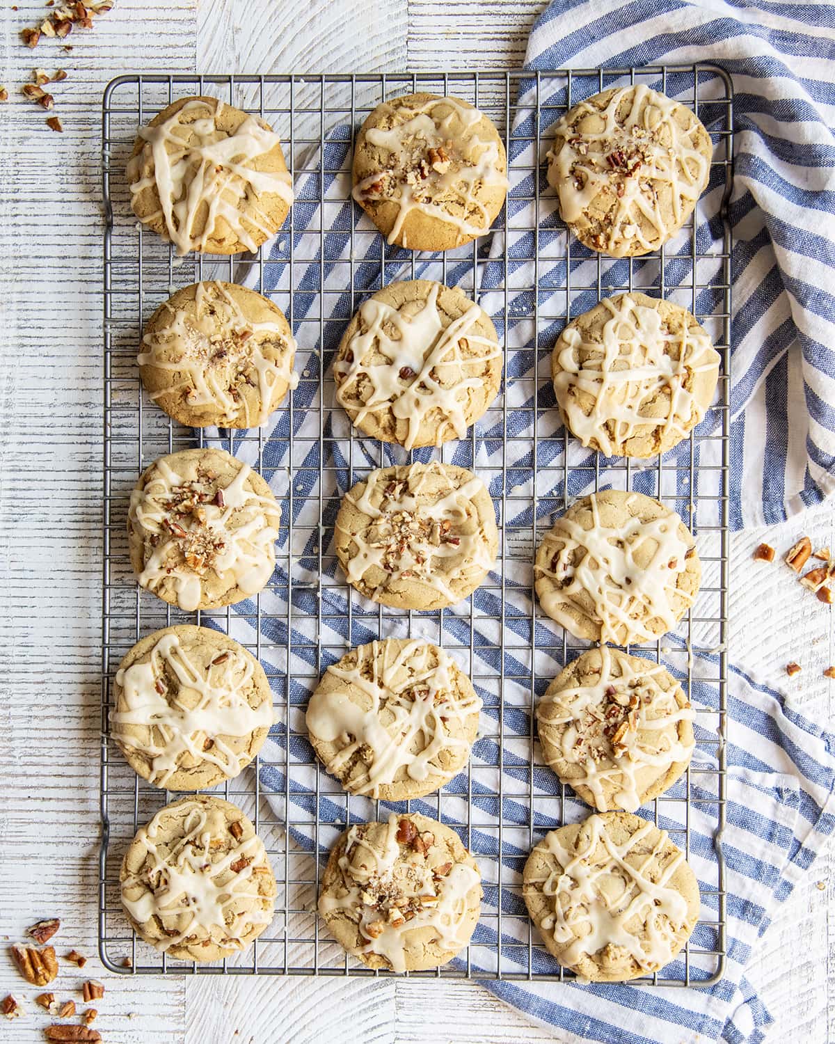 An overhead photo of maple and pecan cookies on a cooling rack each topped with maple icing.