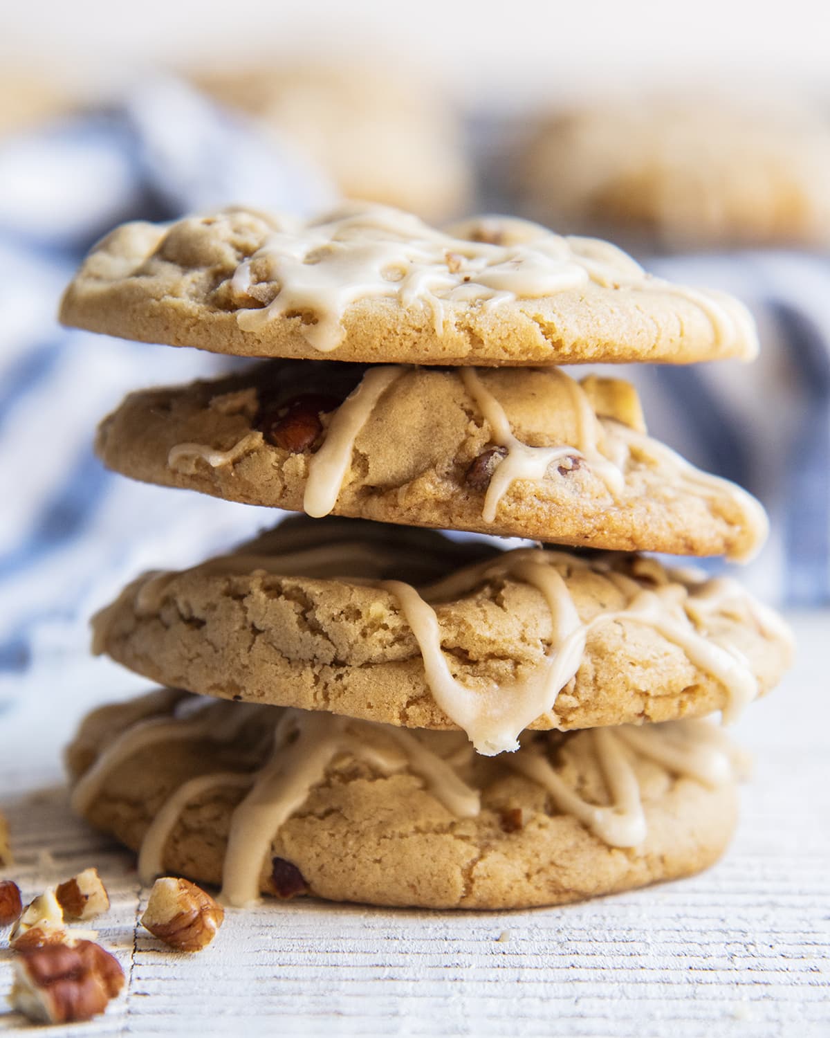 A stack of four cookies topped with drizzles of maple icing.