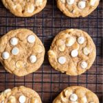 Pumpkin cookies with white chocolate chips topped with a text block for pinterest saying "chewy pumpkin cookies".