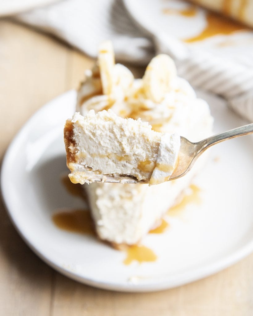 A bite of banana cream pie cheesecake on a fork.