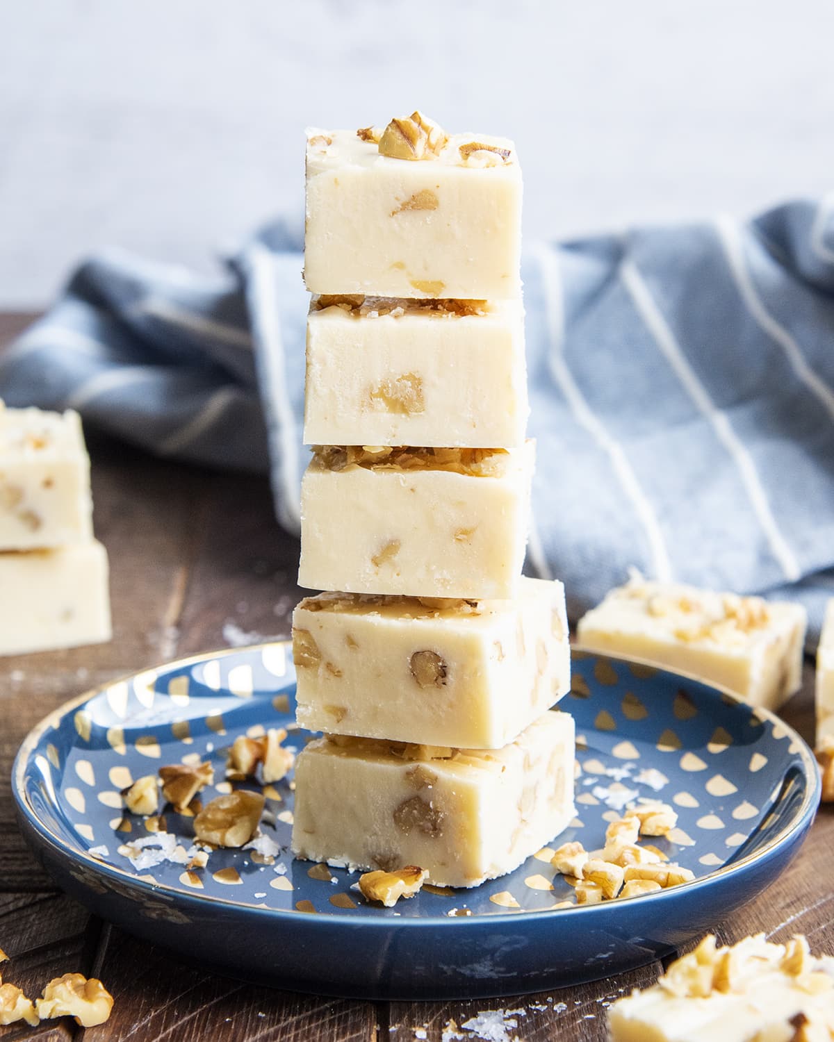 A stack of 5 pieces of maple walnut fudge on a blue plate.
