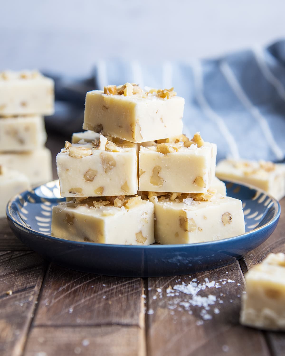 A blue plate topped with white chocolate maple walnut fudge pieces.