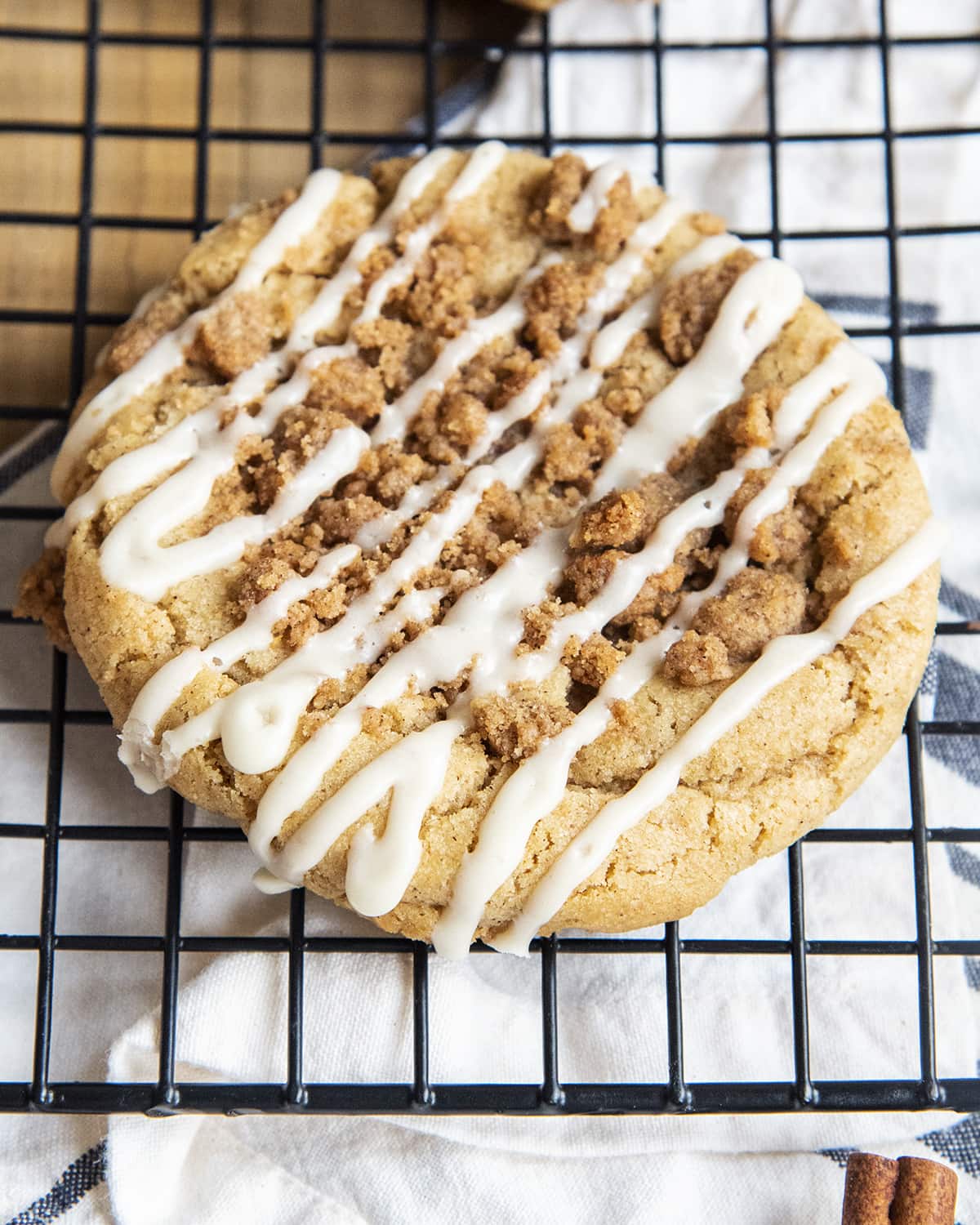 A close up of a giant coffee cake cookie on a cooling rack.
