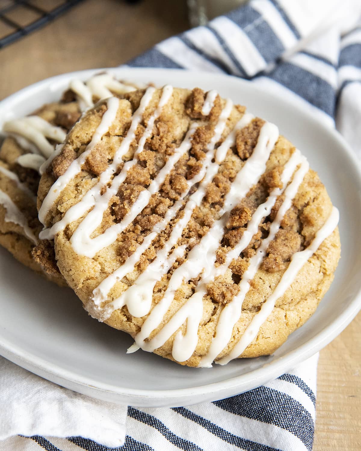 Two giant coffee cake flavored cookies on a white plate.