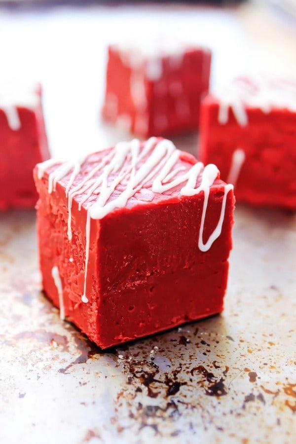 A close up of a piece of red velvet fudge drizzled with white chocolate on the top. 