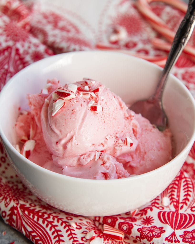 A bowl of peppermint ice cream topped with crushed candy cane pieces.