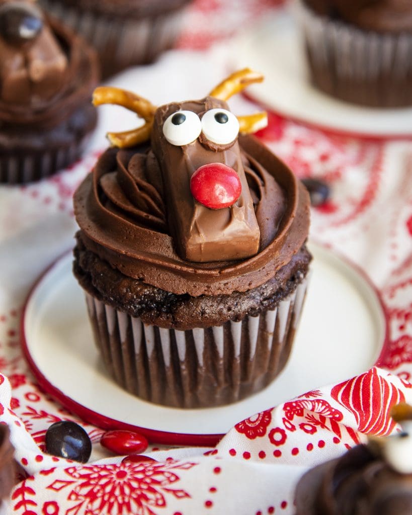 A chocolate reindeer cupcake on a plate.
