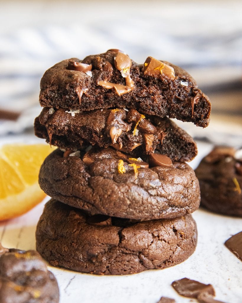 A stack of thick chocolate cookies with melted chocolate pieces on them.
