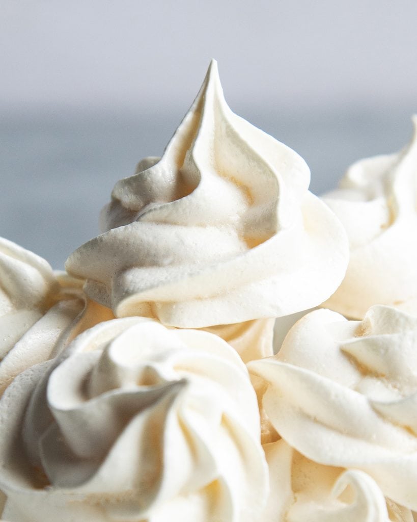 A close up of a piped rosette meringue cookie.