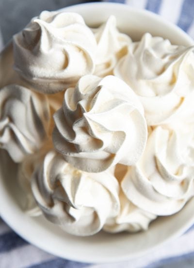 An overhead photo of a bowl of meringue cookies.