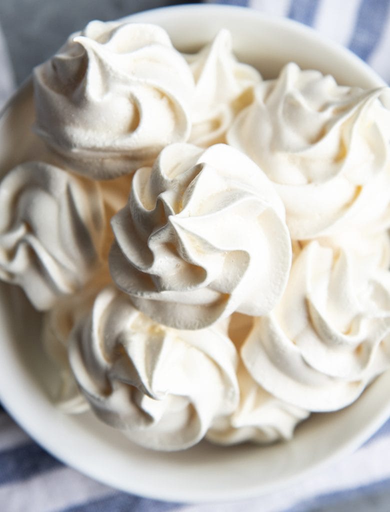 An overhead photo of a bowl of meringue cookies.