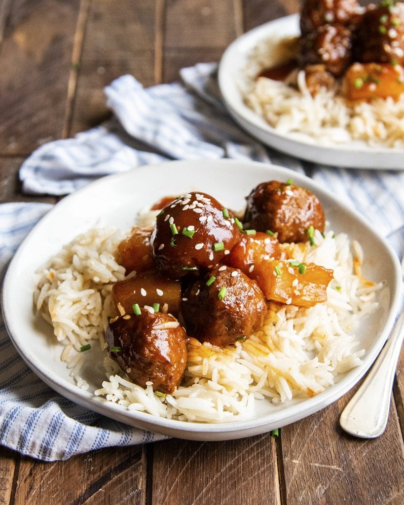 A plate of 3 ingredient hawaiian meatballs on top of rice.