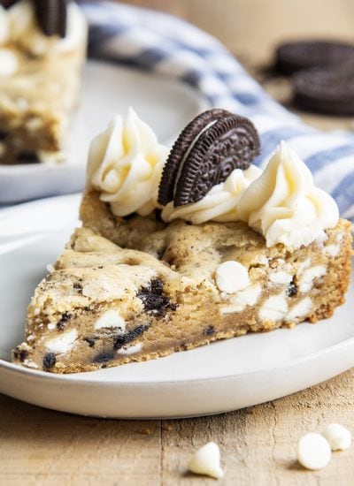 A piece of Oreo cookies and cream cookie cake topped with frosting.