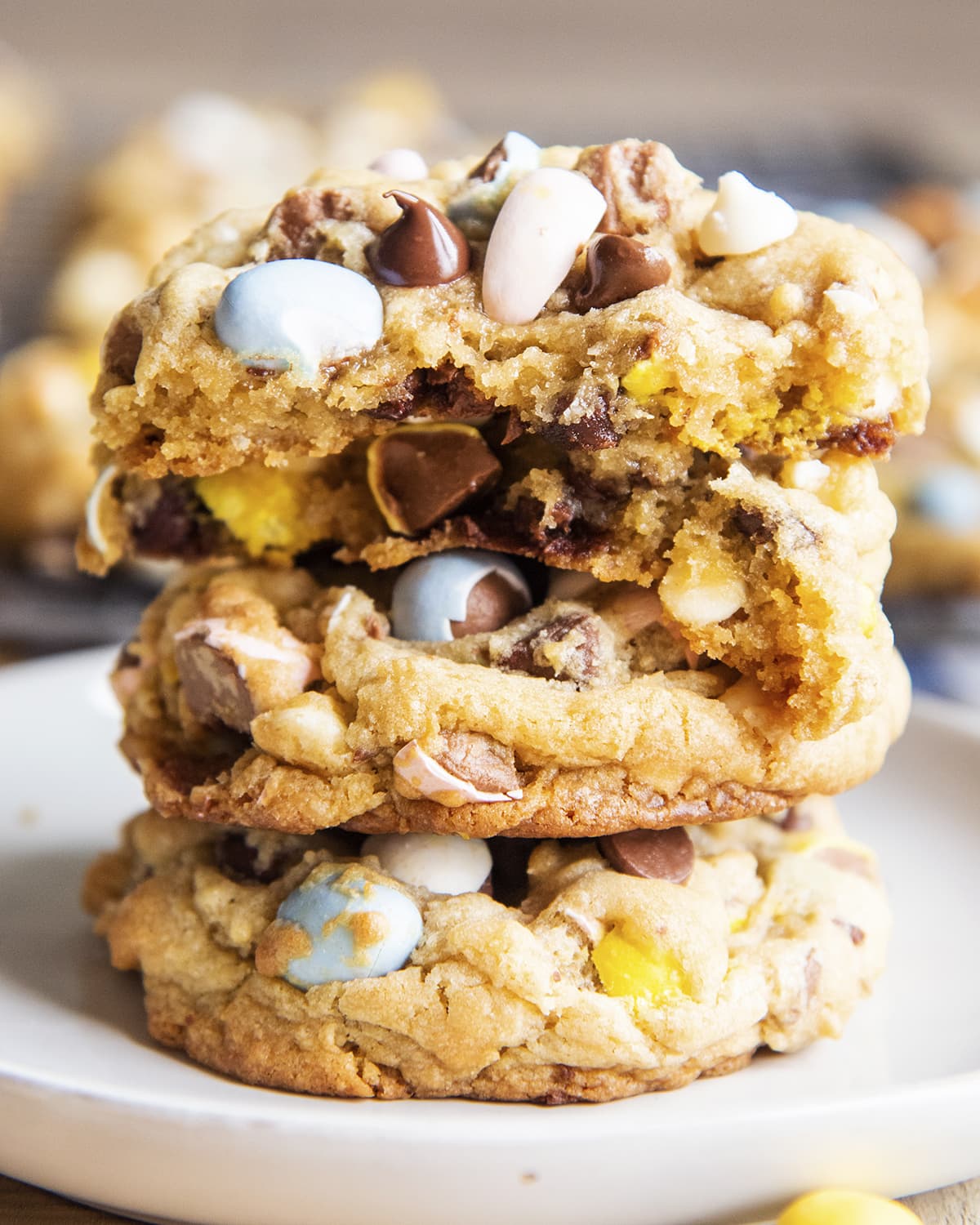A stack of large cookies full of chocolate chips and cadbury mini eggs.