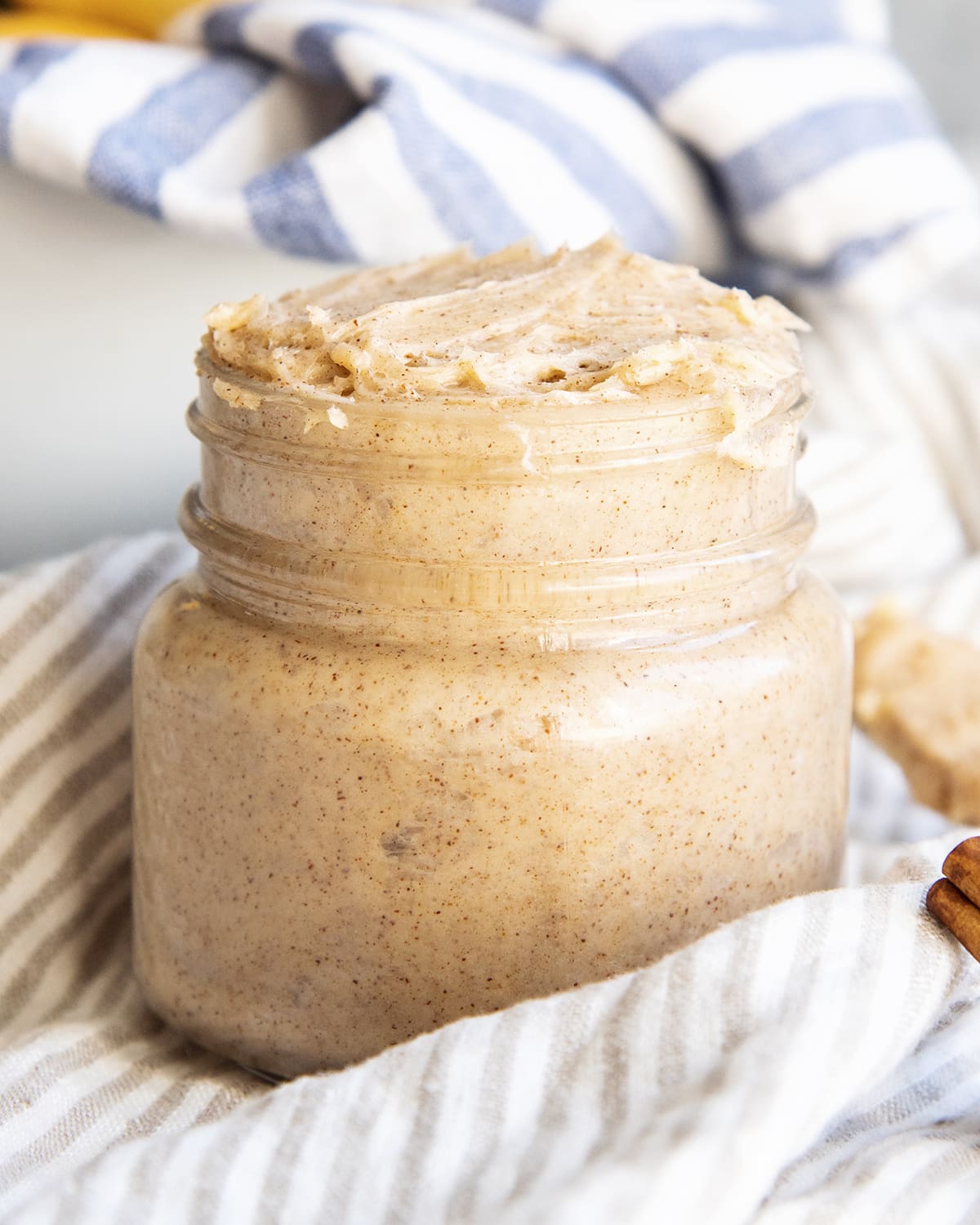 A jar of cinnamon honey butter on a cloth.