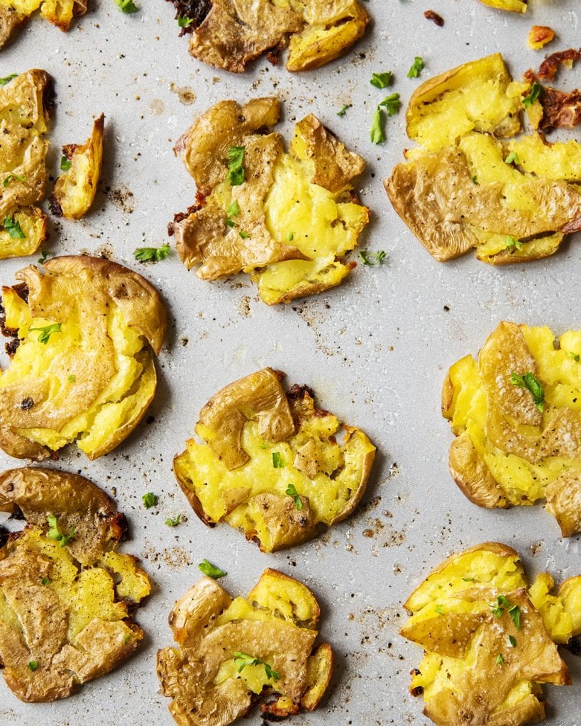 An overhead photo of a pan of golden crispy smashed hot potatoes.