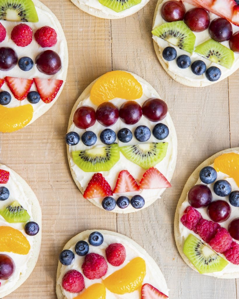 Fruit pizzas shaped like Easter eggs and decorated with rows of fresh fruit.