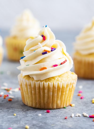 Vanilla Cupcakes topped with buttercream frosting and sprinkles.