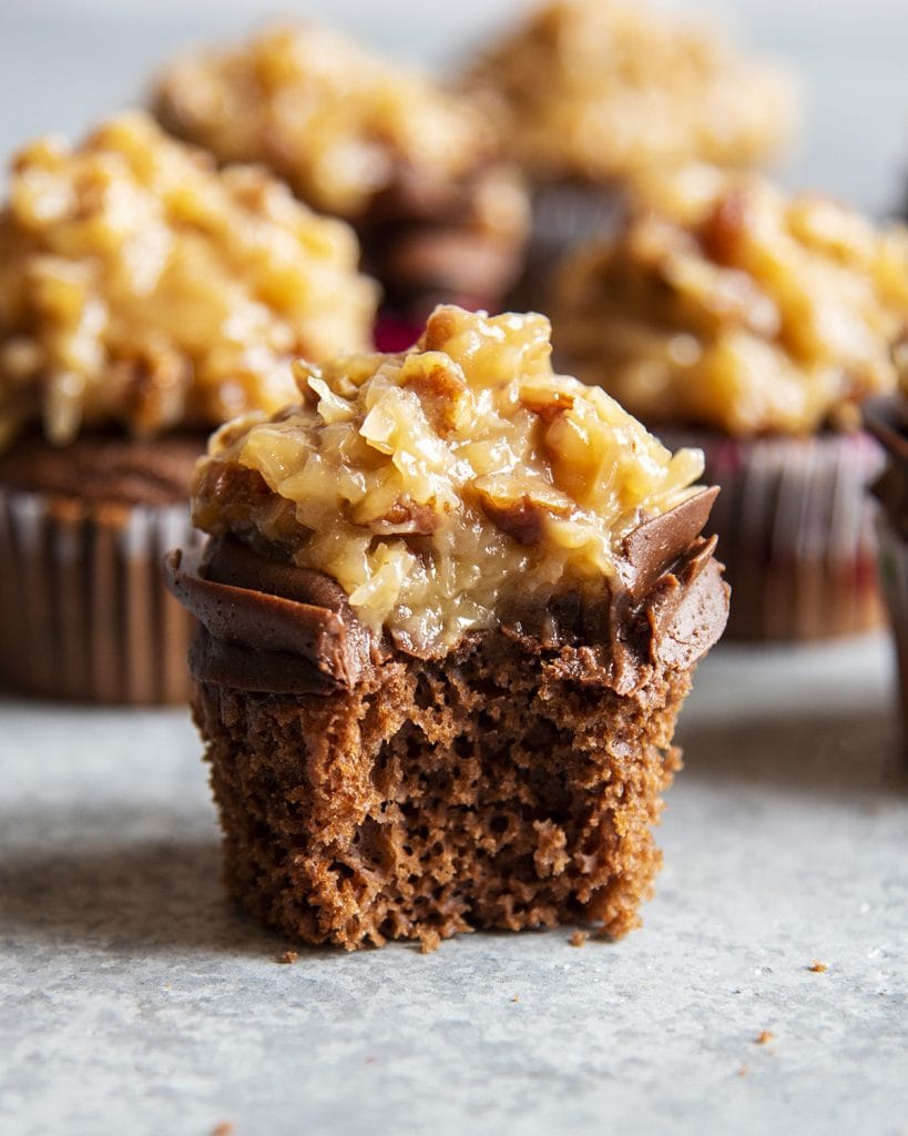 A German chocolate cupcake with a bite out of it.