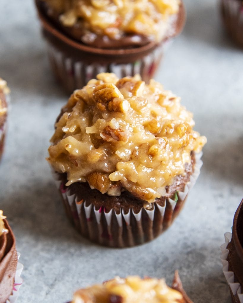A chocolate cupcake topped with coconut pecan frosting.