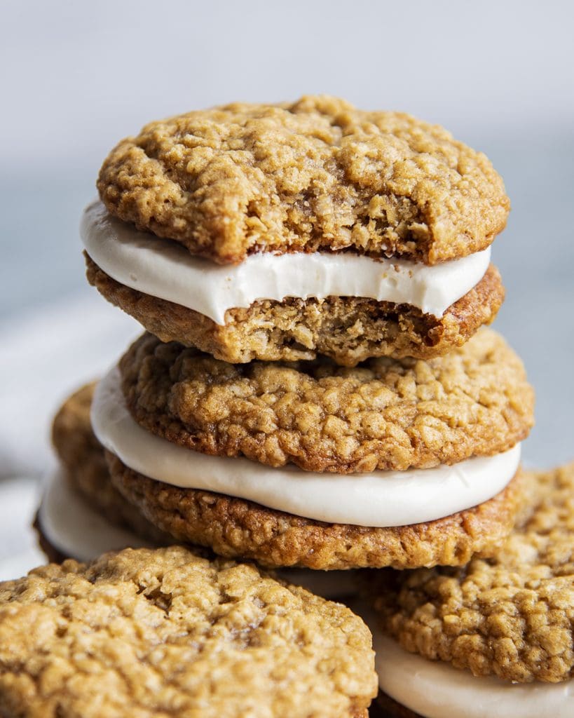 A stack of oatmeal cream pie cookies and the top has a bite out of it.