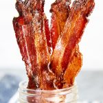 A close up of strips of brown sugar bacon in a jar.