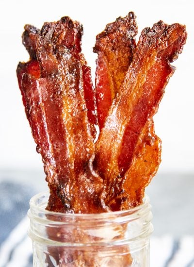 A close up of strips of brown sugar bacon in a jar.
